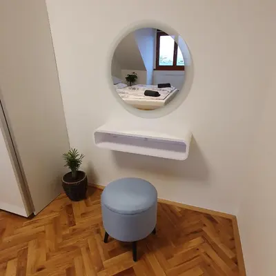 a room with a round mirror and a stool at Prague Castle View Apartment in Prague