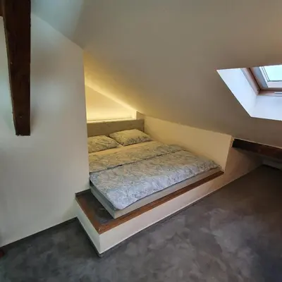 a bed in a small room with a window at Prague Castle View Apartment in Prague