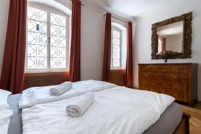 a bedroom with a white bed with two towels on it at Historic Spirit at Studio under the Prague Castle in Prague