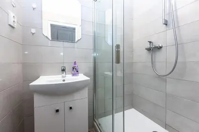 a white bathroom with a shower and a sink at Apartments Safarikova 18 in Prague