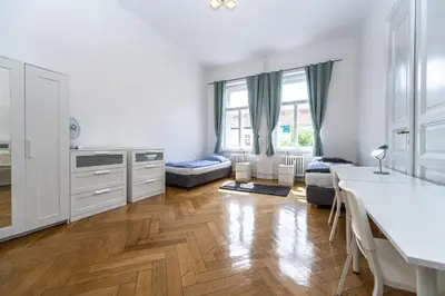 a kitchen with white cabinets and a hard wood floor at Apartments Safarikova 18 in Prague