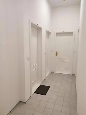 a hallway with white walls and white doors and a tile floor at 420Welcome.Inn in Prague