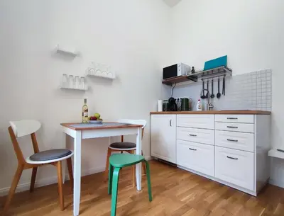 a kitchen with white cabinets and a table and chairs at 420Welcome.Inn in Prague