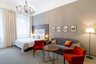 a bedroom with a bed and a couch and a table at Hotel Ikona in Prague