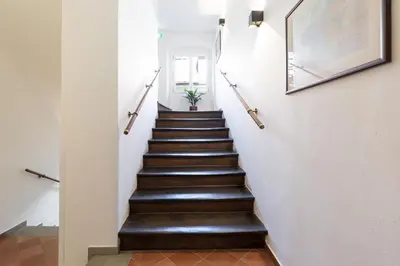 a staircase in a house with wooden floors and white walls at Hotel Ikona in Prague