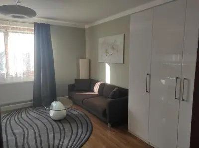 a living room with a couch and a table at DoMo apartment in Středokluky