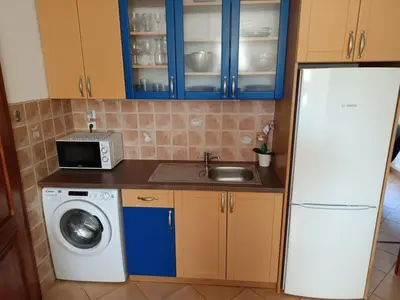 a kitchen with a refrigerator and a sink and a washing machine at DoMo apartment in Středokluky