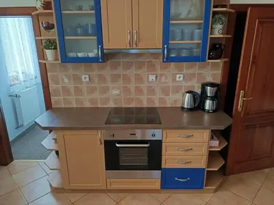 a kitchen with blue cabinets and a stove top oven at DoMo apartment in Středokluky