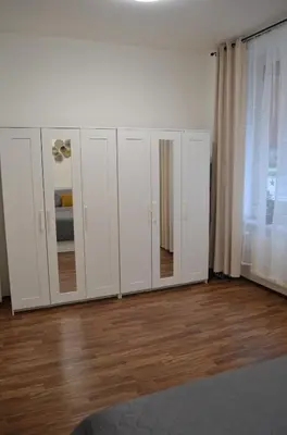a group of white cabinets with mirrors in a room at Apartmán u Fontány in Poděbrady