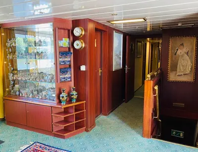 a hallway of a cruise ship with a display case at River hotel KÖNIGSTEIN in Prague
