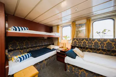 two beds in a train room with two windows at River hotel KÖNIGSTEIN in Prague