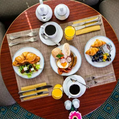 a table topped with plates of breakfast foods and coffee at River hotel KÖNIGSTEIN in Prague