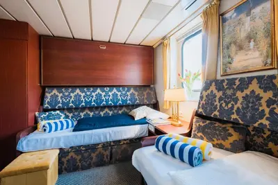 a hotel room with two beds and a table at River hotel KÖNIGSTEIN in Prague