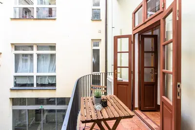a wooden table with plates and glasses on top of it at Charles Apartments in Old Town in Prague