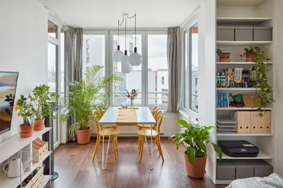 a dining room with a table and chairs and plants at Prague Days - One-bedroom Apartment with Balcony and Garage Parking near the Vltava River in Holešovice in Prague
