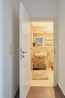 a door leading into a bathroom with a sink at Prague Days - One-bedroom Apartment with Balcony and Garage Parking near the Vltava River in Holešovice in Prague