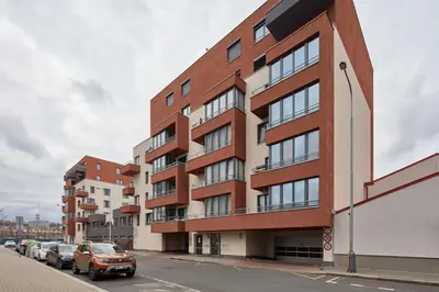 a building on a street with cars parked in front at Prague Days - One-bedroom Apartment with Balcony and Garage Parking near the Vltava River in Holešovice in Prague