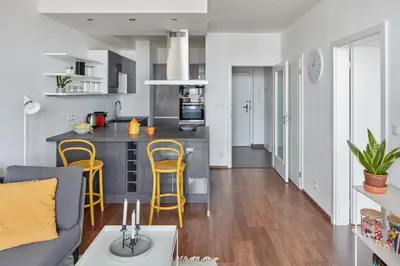 a kitchen and living room with yellow stools in a apartment at Prague Days - One-bedroom Apartment with Balcony and Garage Parking near the Vltava River in Holešovice in Prague