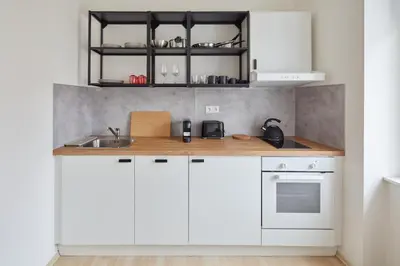 a kitchen with white cabinets and a sink at Prague Days - Old Town Square Apartments in Prague