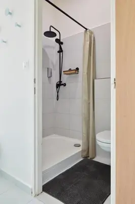a white bathroom with a shower and a toilet at Prague Days - Old Town Square Apartments in Prague