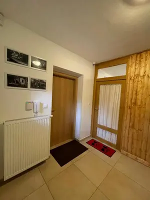 a living room with a door and a red rug at Kersko Apartments in Hradišťko