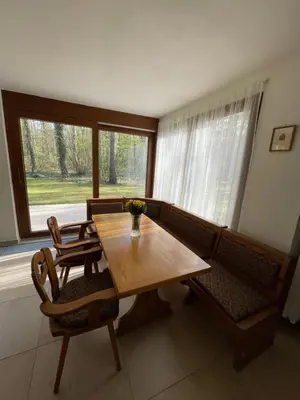 a dining room with a wooden table and chairs at Kersko Apartments in Hradišťko