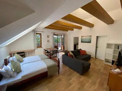 a bedroom with a large bed and a couch at Kersko Apartments in Hradišťko
