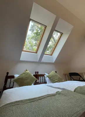 two beds in a bedroom with two windows at Kersko Apartments in Hradišťko