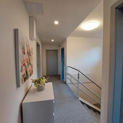 a hallway with stairs and a vase of flowers on a counter at View of Prague in Prague