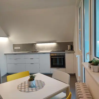 a kitchen with a white table and chairs and a table and a counter at View of Prague in Prague