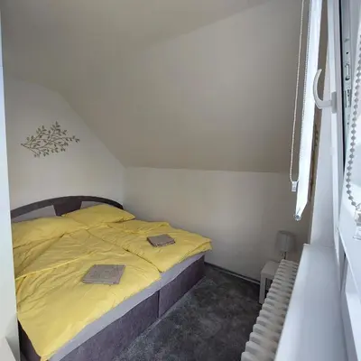 a small bedroom with a bed with yellow sheets at View of Prague in Prague