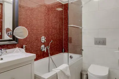 a bathroom with a tub and a sink and a toilet at Louren - The Bridge Inn in Prague