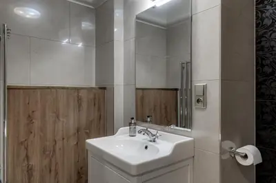 a white bathroom with a sink and a mirror at Louren - The Bridge Inn in Prague
