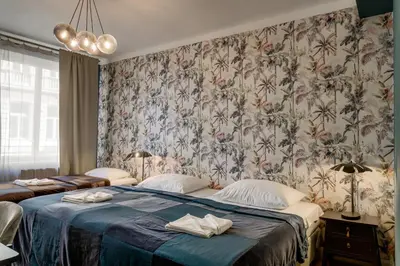 a bedroom with a large bed with a blue blanket at Louren - The Bridge Inn in Prague