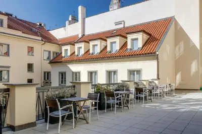 a patio with tables and chairs in front of a building at Louren - The Bridge Inn in Prague