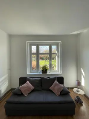 a couch in a living room with a window at Apartmán Na Polabí in Mělník