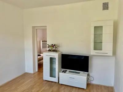 a living room with a tv and a white wall at Apartmán Na Polabí in Mělník
