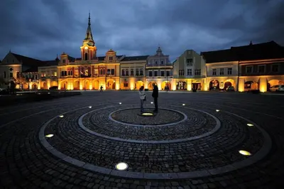 a person standing in front of a building at night at Apartmán Na Polabí in Mělník