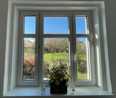 a window with a vase of flowers on a window sill at Apartmán Na Polabí in Mělník