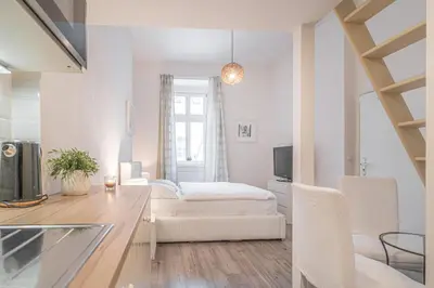 a white living room with a couch and a table at Útulny byt v centru Prahy in Prague