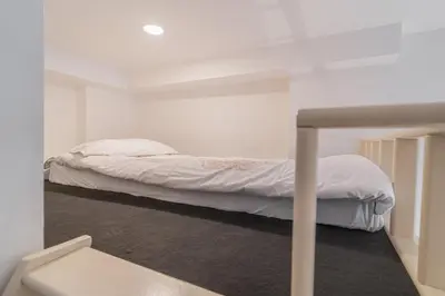 a bedroom with a bed with white sheets at Útulny byt v centru Prahy in Prague