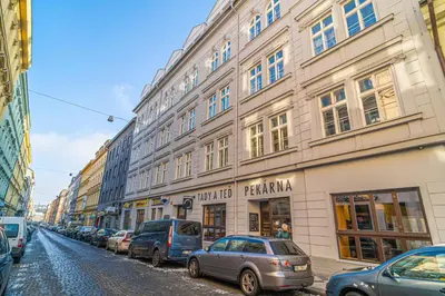 a street with cars parked in front of buildings at Útulny byt v centru Prahy in Prague