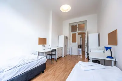 a bedroom with two beds and a desk and desks at Legerova Apartments in Prague