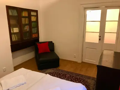 a bedroom with a bed and a chair with a red pillow at Kristian's Old Town Sq. Apartments in Prague