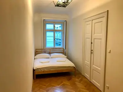 a small bedroom with a bed and a window at Kristian's Old Town Sq. Apartments in Prague