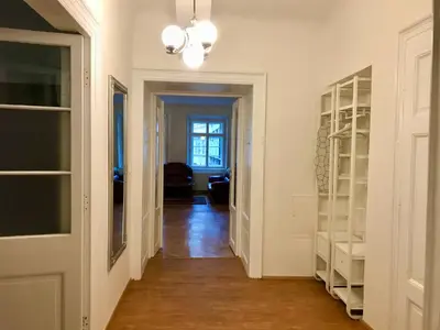 a hallway with white shelves and a room with a door at Kristian's Old Town Sq. Apartments in Prague