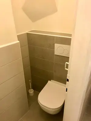 a small bathroom with a toilet in a room at Kristian's Old Town Sq. Apartments in Prague