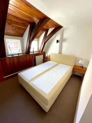 a bedroom with a large bed with a wooden ceiling at Kristian's Old Town Sq. Apartments in Prague