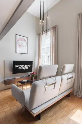a living room with a couch and a tv at Prague Days - Loft with Garage and Workspace right next to Wenceslas Square in Prague