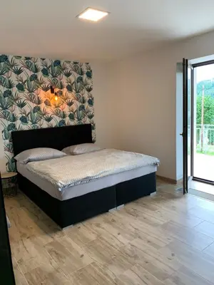 a bedroom with a large bed with a wall at Apartmány Županovice in Dobříš